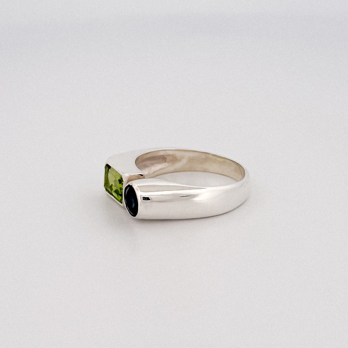 ARANSO III Ring in sterling silver, set with an emerald-cut peridot and round Australian sapphire. Handmade in Melbourne by AGOVIA.