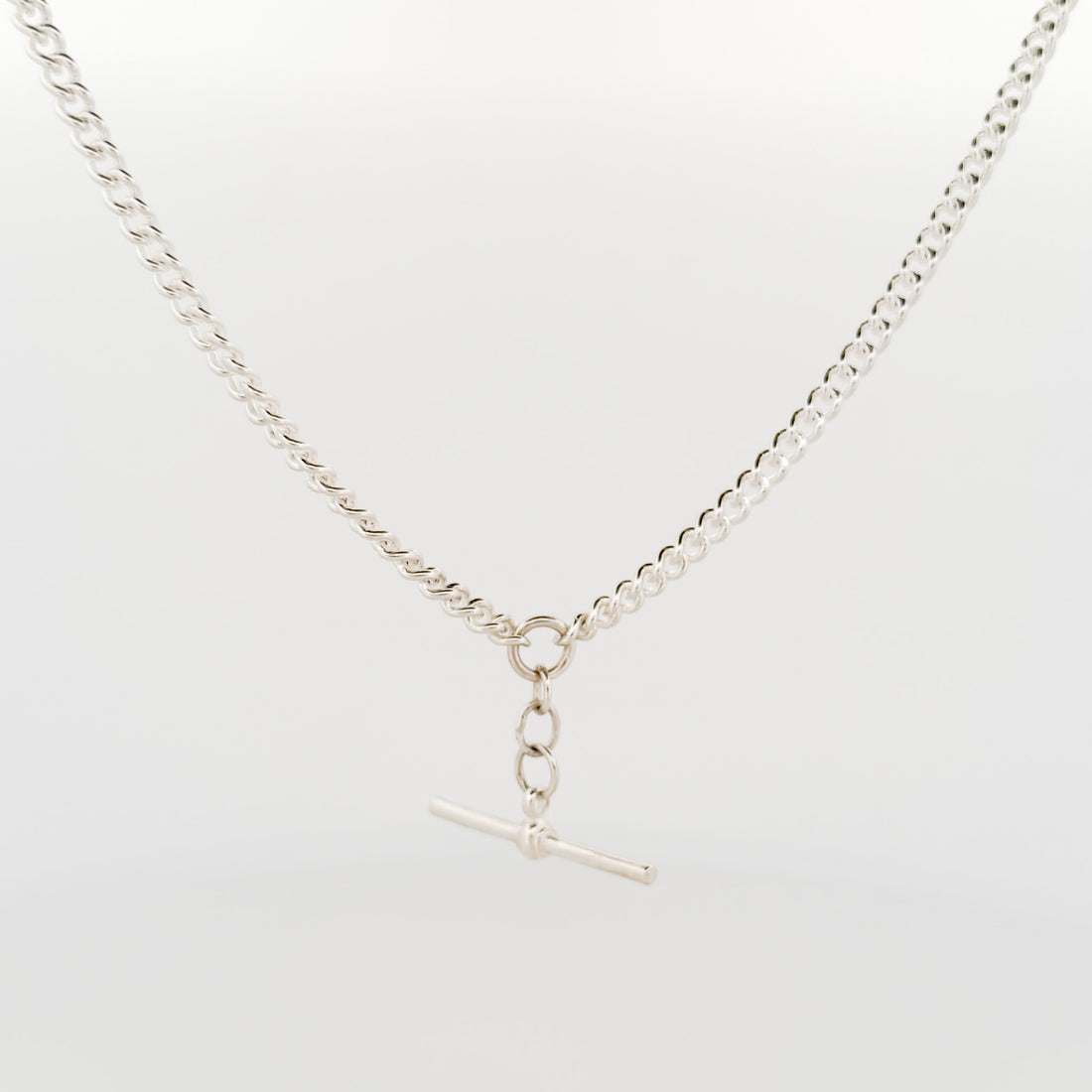Silver necklace with a clasp on a light gray background
