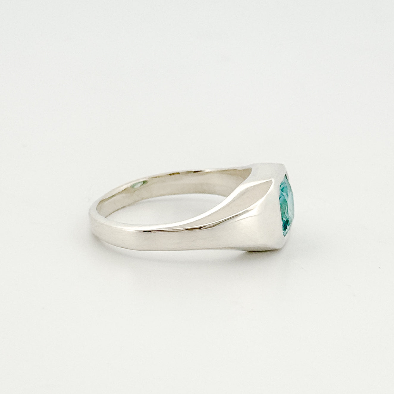 Silver ring with a blue gemstone on a white background