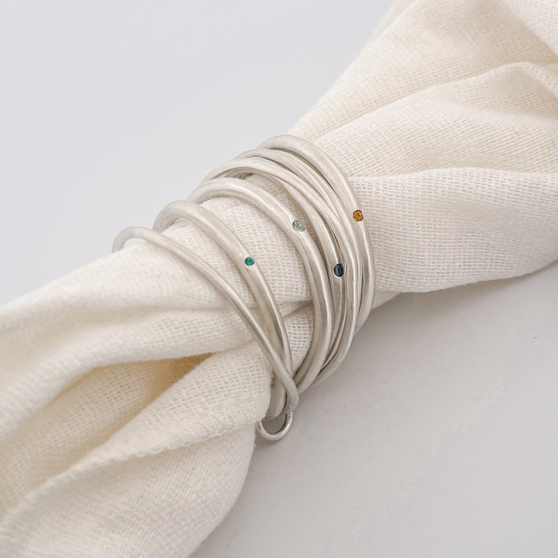 BIGOLI napkin ring set of four in hand-forged sterling silver with aquamarine, citrine, peridot, sapphire and emerald. AGOVIA x Tabletopjoy.