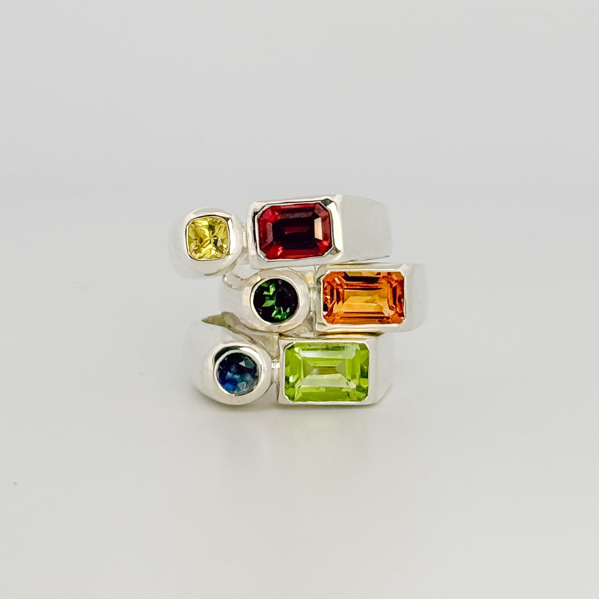 ARANSO III Ring in sterling silver, set with an emerald-cut peridot and round Australian sapphire. Handmade in Melbourne by AGOVIA.