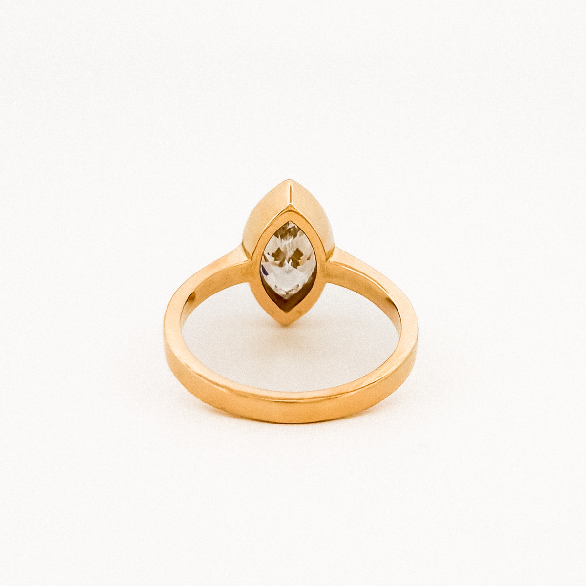 Marquise solitaire engagement ring with bezel-set diamond on a comfort-fit band. Available in gold or platinum. Handmade in Melbourne by AGOVIA.