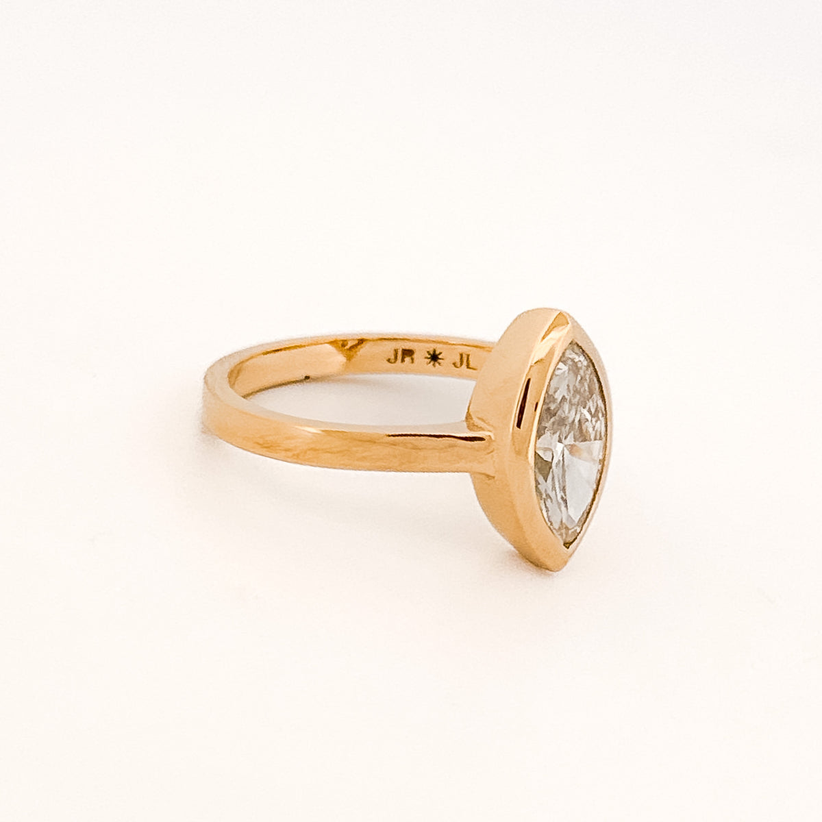 Marquise solitaire engagement ring with bezel-set diamond on a comfort-fit band. Available in gold or platinum. Handmade in Melbourne by AGOVIA.