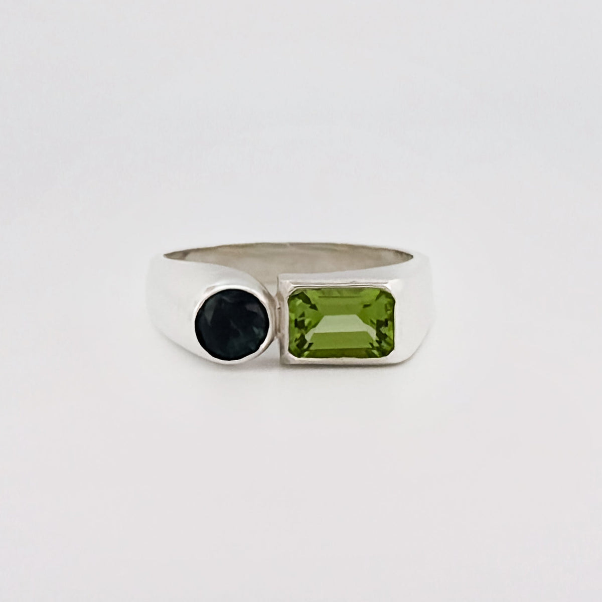 ARANSO III Ring in sterling silver, set with an emerald-cut peridot and round Australian sapphire. Handmade in Melbourne by AGOVIA.