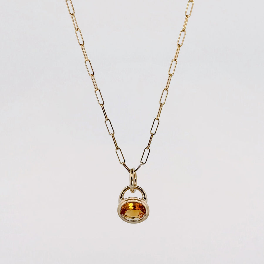 A silver ring and a chain laid on a pale ground