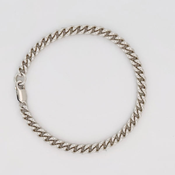 CASPER wrist chain in sterling silver, curb links, laid in a circle.