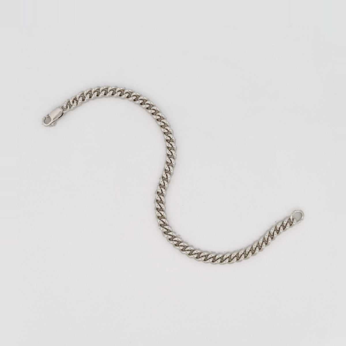 CASPER wrist chain in sterling silver, laid open in a curve.