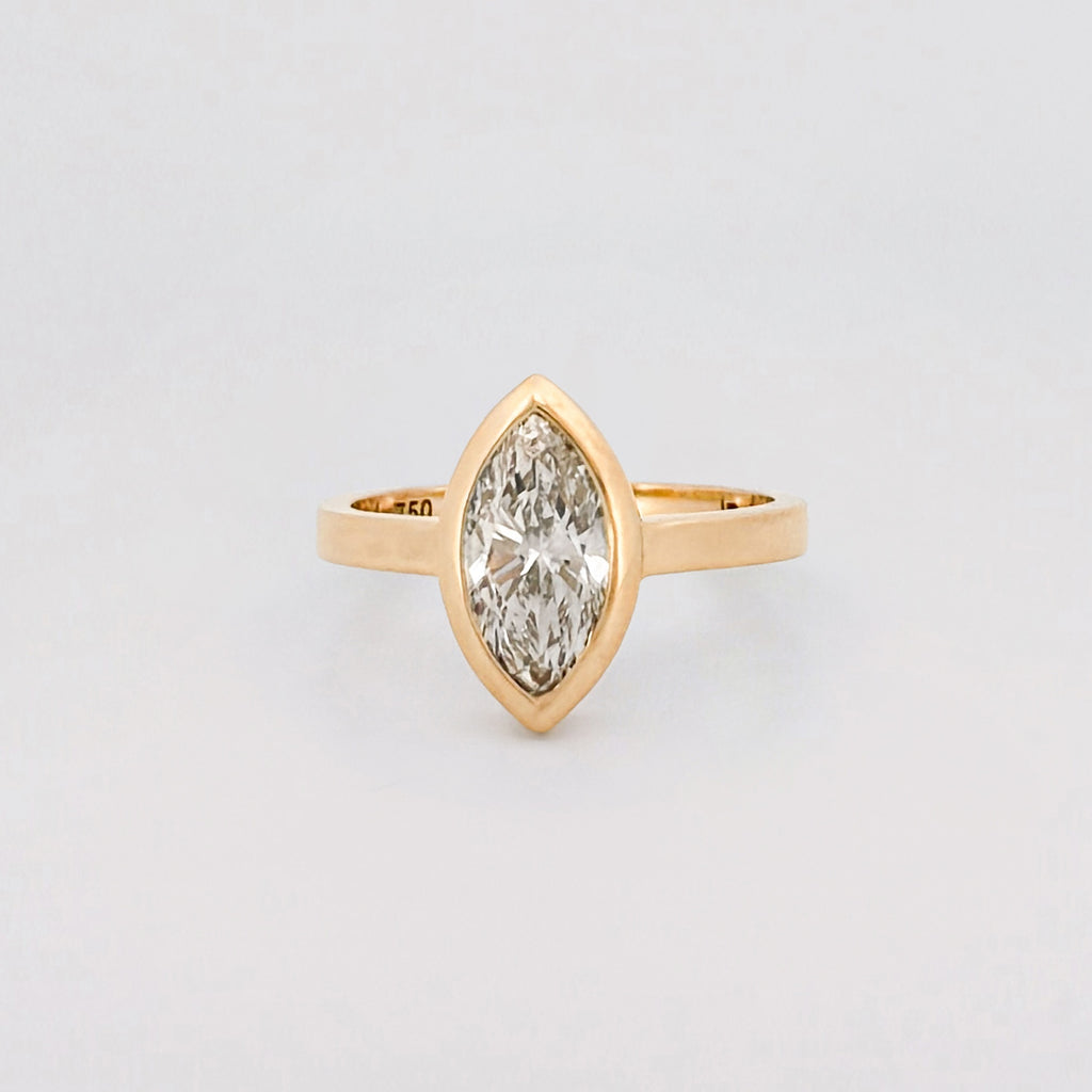 Marquise solitaire engagement ring with bezel-set diamond on a comfort-fit band. Available in recycled gold or platinum. Handmade in Melbourne by AGOVIA.