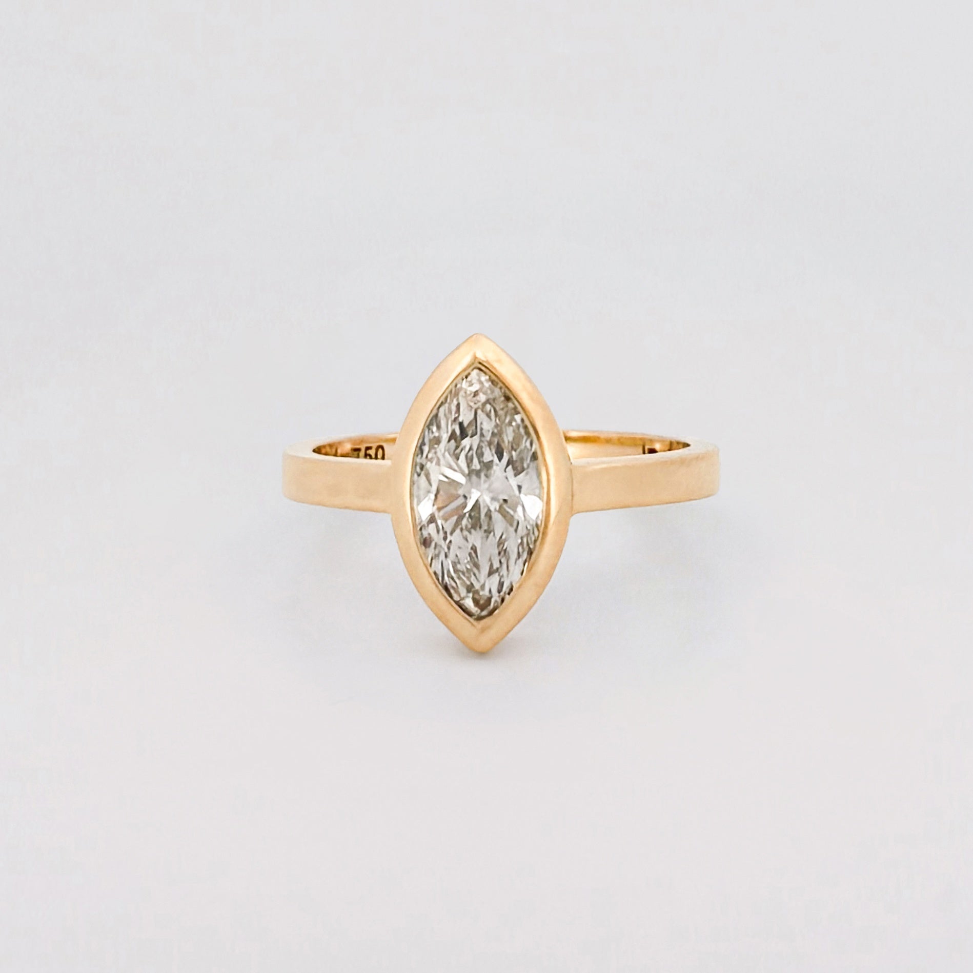 Marquise solitaire engagement ring with bezel-set diamond on a comfort-fit band. Available in recycled gold or platinum. Handmade in Melbourne by AGOVIA.