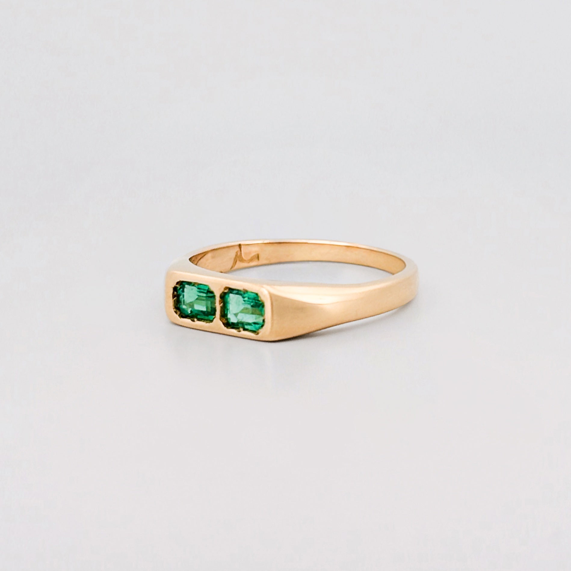 FELIX Ring in recycled 18ct yellow gold, set with two emerald-cut Zambian emeralds. Handmade in Melbourne by AGOVIA.
