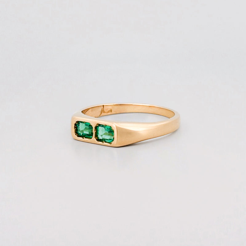 FELIX Ring in 18ct yellow gold, set with two emerald-cut Zambian emeralds. Handmade in Melbourne by AGOVIA.